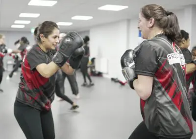 Image of 2 women sparring in a kickboxing class